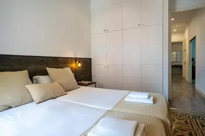 a bedroom with a large white bed with white cabinets at Habitat Apartments Eixample Balconies. in Barcelona