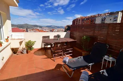 a patio with a table and chairs on a balcony at RentBCN Park Guell in Barcelona