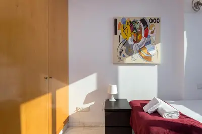 a bedroom with a red bed and a painting on the wall at 1410 - Mediterranean Forum Apartment in Barcelona