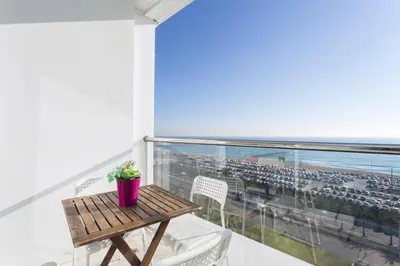 a table and chairs on a balcony with a view of the ocean at 1410 - Mediterranean Forum Apartment in Barcelona