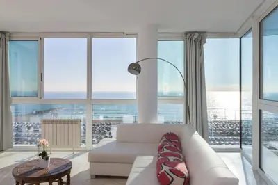 a living room with a white couch and large windows at 1410 - Mediterranean Forum Apartment in Barcelona