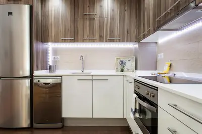 a kitchen with white cabinets and a stainless steel refrigerator at 1324 - OLYMPIC DELUXE in Barcelona