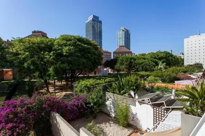 a park with trees and purple flowers and buildings at 1324 - OLYMPIC DELUXE in Barcelona