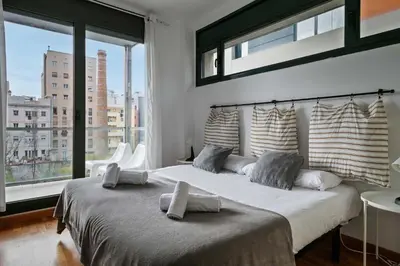 a bedroom with a large bed with a large window at 1213 - Ciutadella Nice Apartment in Barcelona