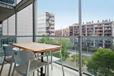 a table on a balcony with a view of a city at 1213 - Ciutadella Nice Apartment in Barcelona