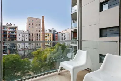 a balcony with two white chairs and a view of a city at 1213 - Ciutadella Nice Apartment in Barcelona