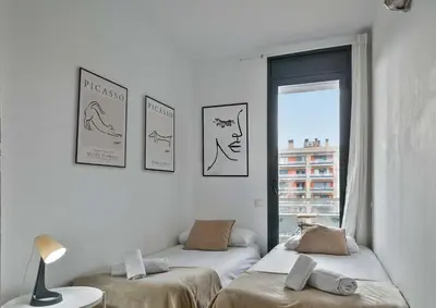 two beds in a room with pictures on the wall at 1213 - Ciutadella Nice Apartment in Barcelona