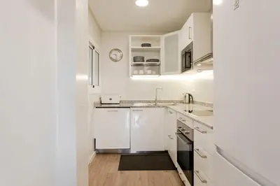 a kitchen with white cabinets and a sink at Cozy Apartment near Fira Gran Via with AC in Hospitalet de Llobregat