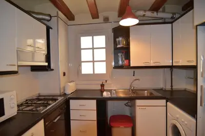 a kitchen with white cabinets and a sink and a window at Central Apartment in Barcelona
