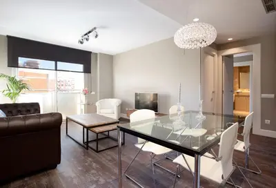 a dining room with a glass table and white chairs at Calabria Luxury in Barcelona