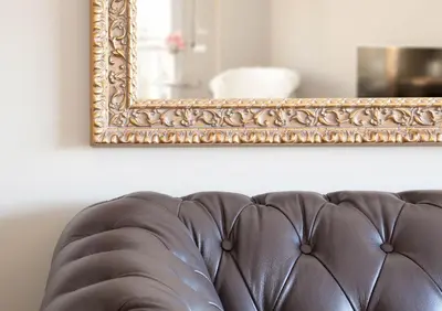 a brown leather couch in front of a mirror at Calabria Luxury in Barcelona