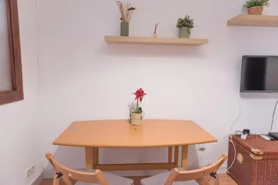 a wooden table with two chairs and a flower on it at Sweet BCN Studio with Terrace in Barcelona