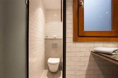 a small bathroom with a toilet and a window at Trafalgar Luxury in Barcelona