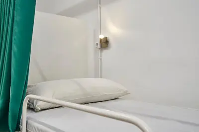 a hospital room with a bed with a pillow at Hola Hostal Collblanc in Hospitalet de Llobregat