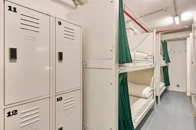 a room with bunk beds and green curtains at Hola Hostal Collblanc in Hospitalet de Llobregat