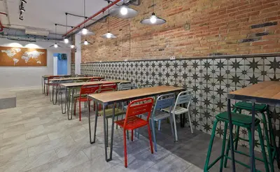 a row of tables and chairs in a restaurant at Hola Hostal Collblanc in Hospitalet de Llobregat