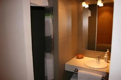 a bathroom with a sink and a mirror at Apartamentos Bejar in Barcelona