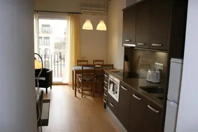a kitchen with a table and a dining room at Apartamentos Bejar in Barcelona