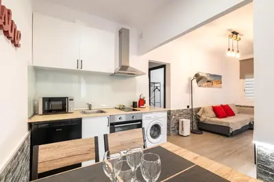 a kitchen and living room with a couch in the background at Beach Apartment, next to the sea in Premiá de Mar