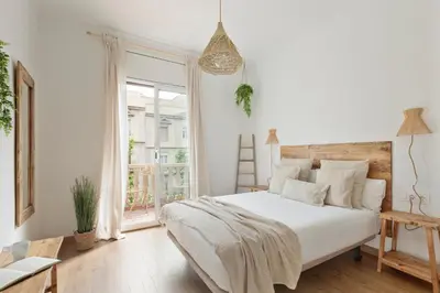 a white bedroom with a large bed and a window at KeyFamily Sweet Home in Barcelona