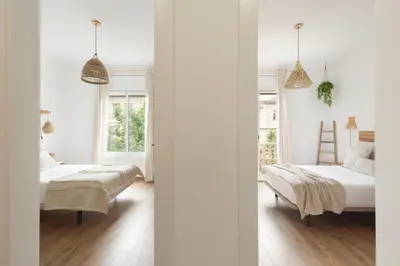 two beds in a bedroom with white walls at KeyFamily Sweet Home in Barcelona