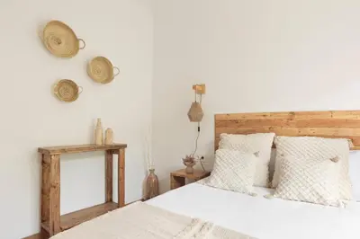 a bedroom with a bed with a wooden headboard and pillows at KeyFamily Sweet Home in Barcelona