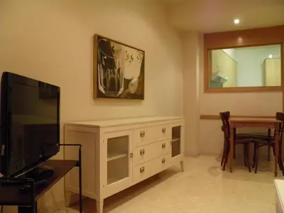 a living room with a tv and a dresser and a table at Apartaments St. Jordi Comtal in Barcelona