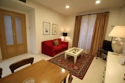 a living room with a red couch and a table at Apartaments St. Jordi Comtal in Barcelona