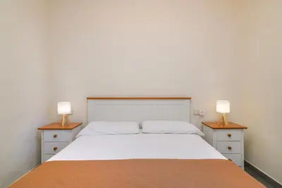 a bedroom with a white bed with two night stands at Apartaments Rural Montseny in gualba de Dalt