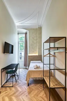 a bedroom with a bed and a chair and a desk at Ella Hostel Boqueria in Barcelona