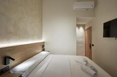 a bedroom with a white bed with two towels at Ella Hostel Boqueria in Barcelona
