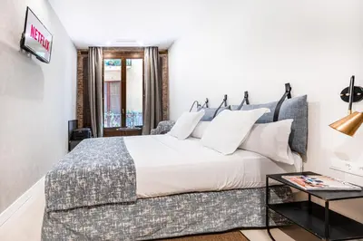 a bedroom with a large bed and a table at Casa Lirio in Barcelona