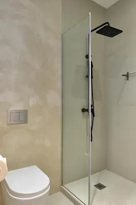 a bathroom with a toilet and a glass shower at Casa Lirio in Barcelona