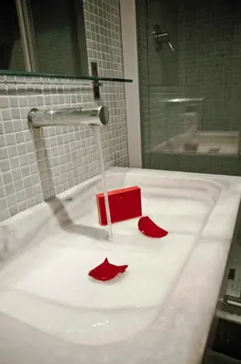 a bathroom sink with red flower pedals on it at Barceloneta Suites Apartments Beach in Barcelona