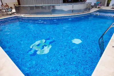 a pool of blue water with a shark in it at Hotel Haromar in Calella