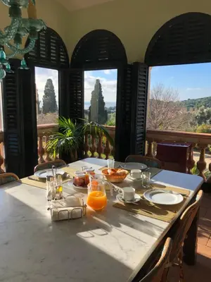 a table with food on it in a room with windows at B&B Can Casadella in Premia de Dalt