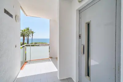 a hallway with a door leading to a balcony with the ocean at Hauzify I Apartaments Sot del Morer in San Pol de Mar