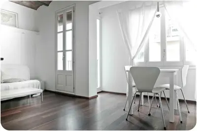 a white room with a table and chairs and a bed at Barceloneta Suites Apartments Market in Barcelona