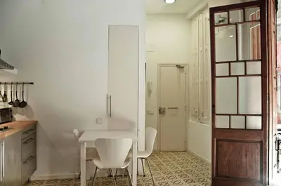 a dining room with a white table and chairs at Barceloneta Suites Apartments Market in Barcelona