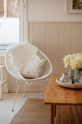 a white chair with a pillow on a table at Sitges Holiday Apartment in Sitges