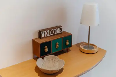 a table with a welcome sign and a lamp on it at Sitges Holiday Apartment in Sitges