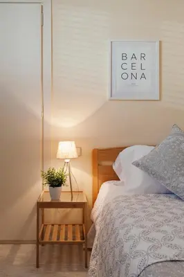 a bedroom with a bed and a table with a lamp at Sitges Holiday Apartment in Sitges