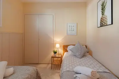 a small bedroom with a bed and a table at Sitges Holiday Apartment in Sitges