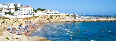 a group of people in the water at a beach at Sitges Holiday Apartment in Sitges