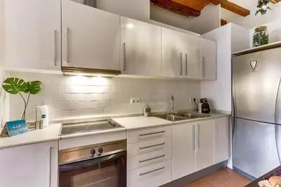 a kitchen with white cabinets and a stainless steel refrigerator at Sweett - Ausias Marc in Barcelona