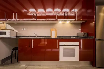 a kitchen with red cabinets and a sink at Novus Homes Barcelona Poble Sec in Barcelona