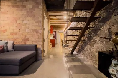 a living room with a couch and a stone wall at Novus Homes Barcelona Poble Sec in Barcelona