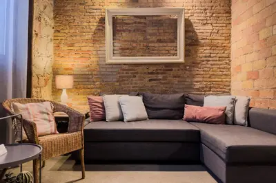a living room with a couch and a brick wall at Novus Homes Barcelona Poble Sec in Barcelona