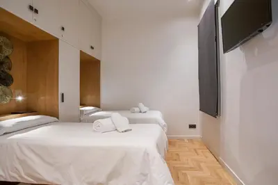 a room with two beds and a flat screen tv at Tendency Sagrada Familia Luxury in Barcelona