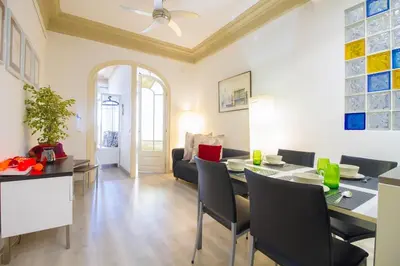 a dining room and living room with a table and chairs at Armapana in Barcelona